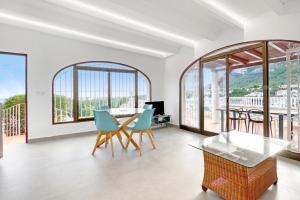 a dining room with a table and chairs and windows at Ericito in Denia