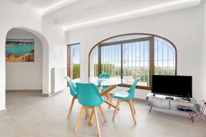 a dining room with a table and chairs and a tv at Ericito in Denia