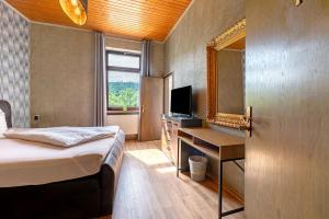 a bedroom with a bed and a mirror and a desk at Gästezimmer St Wendel in Prüm