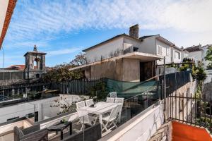a balcony with a table and chairs on a building at Aquedarte in Lisbon