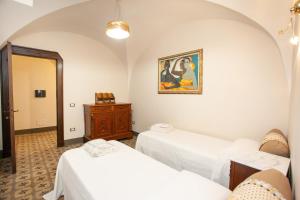 a room with two beds and a painting on the wall at Hora Vona in Orosei