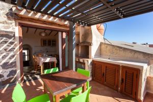 a patio with a table and a sink and a kitchen at Hora Vona in Orosei