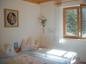 a bedroom with two beds and a window at Gmosnhof Mölten in Meltina