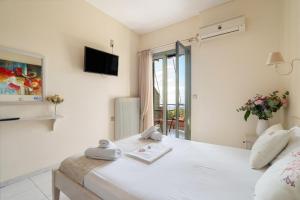 a bedroom with a bed and a tv on the wall at Nontas Home 23 in Kalamitsi