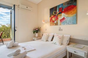 a bedroom with a white bed and a window at Nontas Home 23 in Kalamitsi