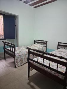 a bedroom with two beds and a window at Fazenda São Leandro in Rio das Flores