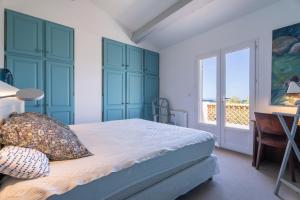 a bedroom with a bed with blue cabinets and a window at Villa Baliba in Hyères
