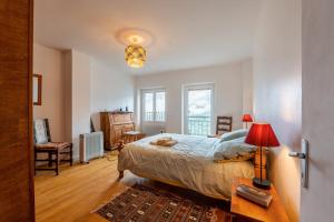 a bedroom with a bed and a table with a lamp at Volets Verts in Aime-La Plagne