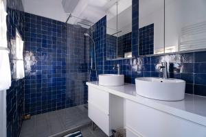 a bathroom with two sinks and blue tiles at Villa Baliba in Hyères +29 photos