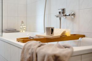 a bathroom sink with a book and a cup of coffee at Ferienwohnung Am Buchbühl in Stockach