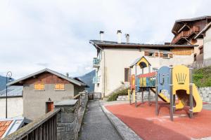 a playground with a slide in front of a building at Volets Verts in Aime-La Plagne