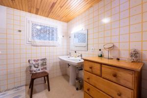 a bathroom with a sink and a mirror and a chair at Volets Verts in Aime-La Plagne +17 photos