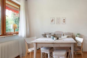 a white dining room table with chairs and a window at Ferienwohnung Am Buchbühl in Stockach +24 photos