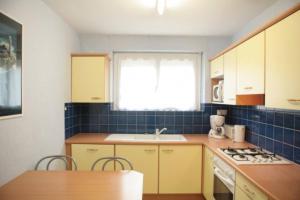 a kitchen with yellow cabinets and a sink and a window at L'avocette in Sarzeau