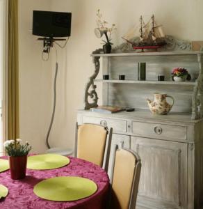 a dining room with a table and chairs and a tv at L'avocette in Sarzeau