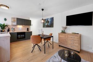a living room with a table and a kitchen at Baumschule Rombach - 'Spatzennest' in Herbolzheim