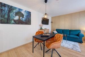 a living room with a table and a blue couch at Baumschule Rombach - 'Spatzennest' in Herbolzheim
