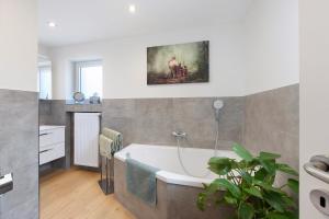 a bathroom with a tub and a painting on the wall at Baumschule Rombach - 'Spatzennest' in Herbolzheim +42 photos
