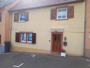 a house with a brown door and windows at Chez Jeanne, charmante maison in Dossenheim-sur-Zinsel