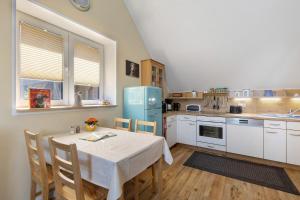 a kitchen with a table and a blue refrigerator at Ferienhof am See in Alt Zeschdorf