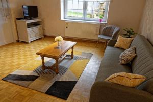 a living room with a couch and a coffee table at Chez Jeanne, charmante maison in Dossenheim-sur-Zinsel