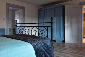 a bedroom with a bed and a blue cabinet at Chez Jeanne, charmante maison in Dossenheim-sur-Zinsel