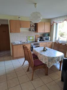 a kitchen with a table and some chairs and a table and a kitchen at Hof Gerbert in Halenbeck