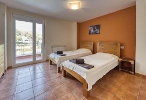 two beds in a room with a large window at Costacabana - Villa Nicky in Lloret de Mar +13 photos
