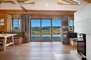 a living room with a table and a large glass door at Bergchalet 2 in Freyung