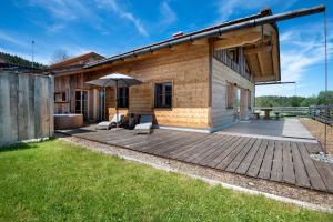 a house with a deck with an umbrella at Bergchalet 2 in Freyung