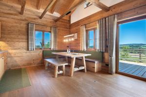 a dining room with a table and a large window at Bergchalet 2 in Freyung +18 photos