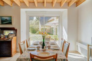 a dining room with a table with a vase of flowers at La ferme d'Alcide in Québriac