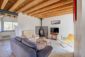 a living room with a couch and a tv at La ferme d'Alcide in Québriac