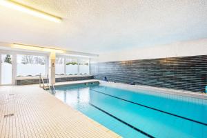 a swimming pool with blue water in a building at Ferienappartement Möhnesee mit Pool in Möhnesee