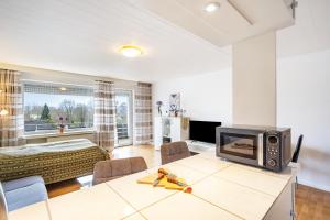 a living room with a table with a tv at Ferienappartement Möhnesee mit Pool in Möhnesee