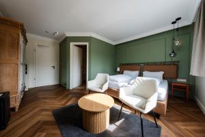 a living room with a bed and two chairs and a table at Aux Tanneries de Wiltz in Wiltz +40 photos