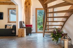Eine Treppe in einem Wohnzimmer mit Stühlen und einem Tisch in der Unterkunft Grotthof in Deutschnofen
