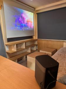 a room with a large projection screen in a room at Tiny House 'bada' Vue Mer in Langueux