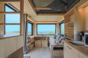 a tiny house with a large living room with windows at Tiny House 'bada' Vue Mer in Langueux