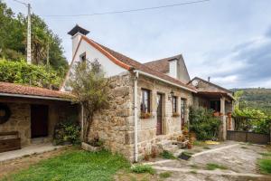an old stone house with a garden in the yard at C Vilamide in Parada de Achas