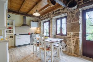 a kitchen with a table and chairs in a room at C Vilamide in Parada de Achas