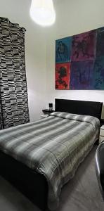 a bedroom with a large bed with a painting on the wall at Casa baja in Bacoli