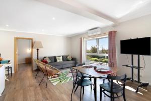 a living room with a table and chairs and a couch at Casa no Campo com vista mar in Loulé