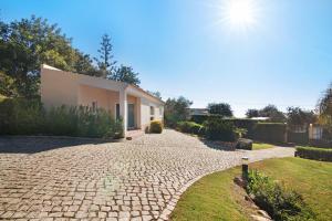 a house with a stone driveway in front of it at Casa no Campo com vista mar in Loulé
