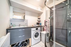 a bathroom with a sink and a washing machine at Chalet Les Mios, chez Isa in Vacheresse