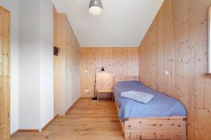 a bedroom with a bed in a wooden wall at Ostseeseele in Parin