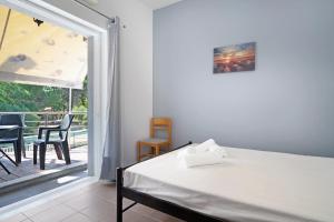 a bedroom with a bed and a balcony at Iguana studio 8 in Preveza