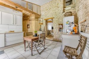 a kitchen with a wooden table and chairs at Maison calme d'Amélie in Saint-Germain-dʼEsteuil