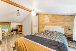 a bedroom with a bed and a wooden wall at Maison calme d'Amélie in Saint-Germain-dʼEsteuil