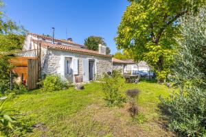 a small stone house in a yard with a tree at Maison calme d'Amélie in Saint-Germain-dʼEsteuil